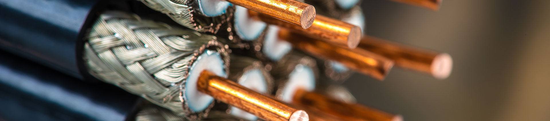 A close-up image showcasing the intricate structure of coaxial cables. The photo highlights the copper conductors, braided shielding, and dielectric insulation, emphasizing the durability and precision design.