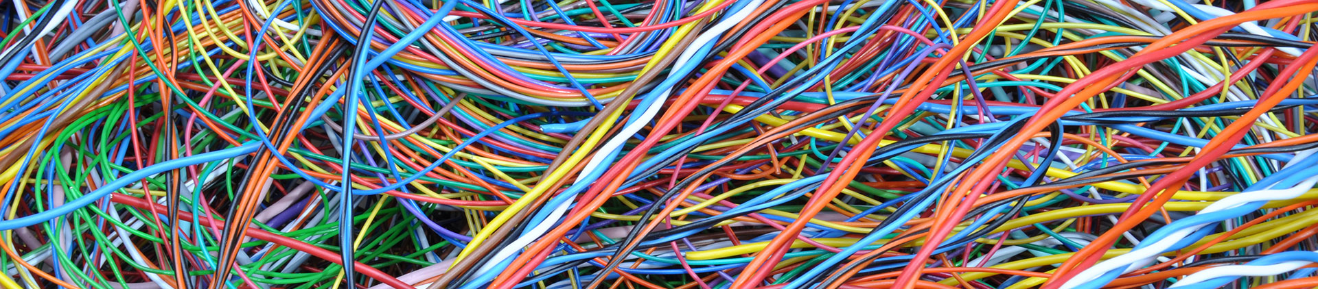 Close-up image of a tangled collection of colorful network cables, including blue, red, orange, green, and yellow wires, showcasing their vibrant insulation and variety.