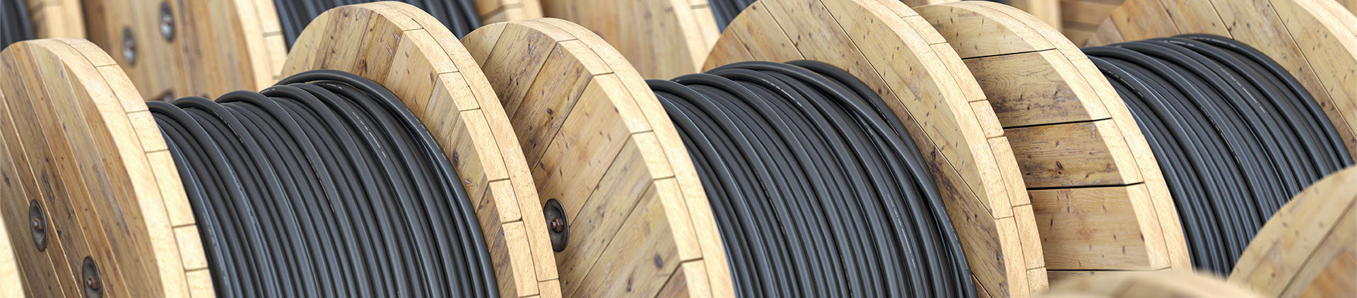 A close-up view of wooden spools neatly wound with black Cat7 bulk Ethernet cable, showcasing the durable and high-quality construction suitable for professional networking installations.