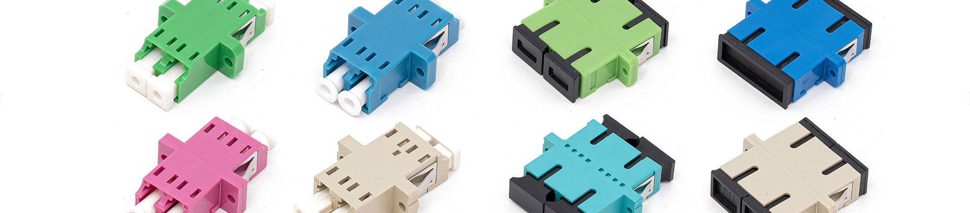 Close-up image of various fiber optic adapters in multiple colors, including green, blue, pink, and beige, arranged neatly on a white background, showcasing their variety and functionality for fiber optic network connections.