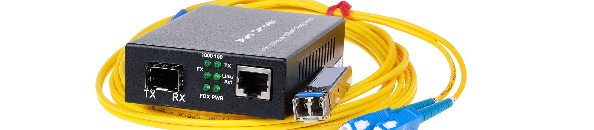 Close-up image of a fiber optic media converter with a yellow fiber optic cable and blue LC connectors, showcasing the device's ports and LED indicators for TX, RX, and power status.
