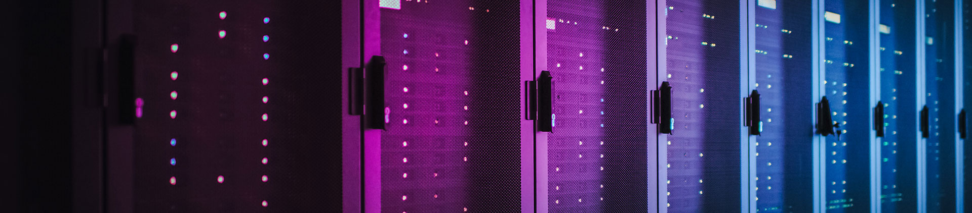 Image of a row of server racks in a data center, illuminated by vibrant purple and blue lighting, highlighting the modern and high-tech environment.