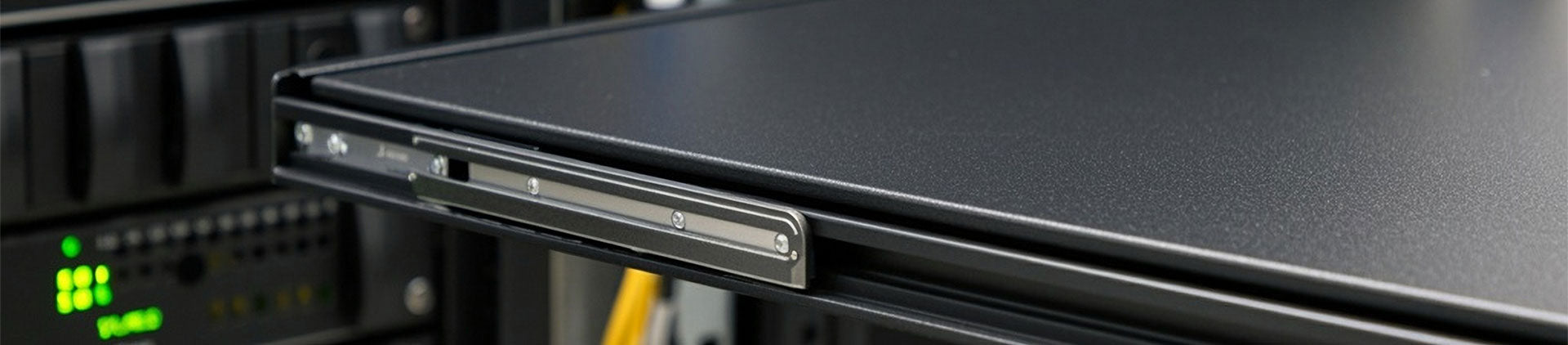 Close-up of a black sliding metal server shelf partially extended from a rack, with visible rails and screws.