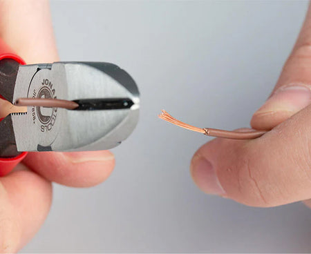 Close-up of telecom diagonal cutting pliers trimming a wire