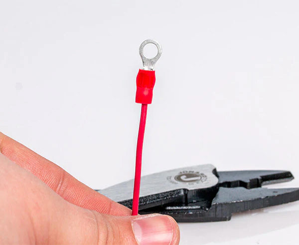 A person preparing to crimp a terminal with the red-handled crimper and cutter