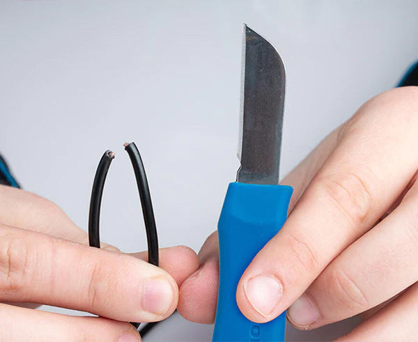 Close-up of hands gripping Network Technician's splicing knife
