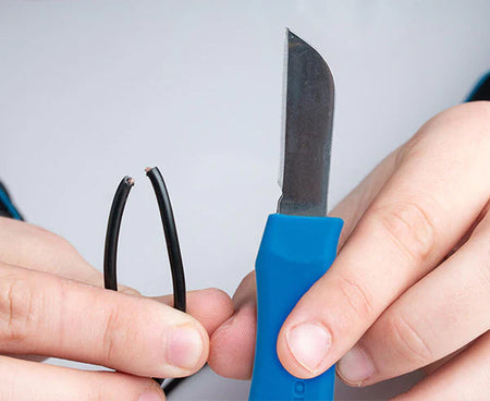 Close-up of hands gripping Network Technician's splicing knife