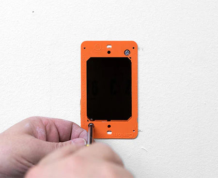 Professional installing a wall box using the template and level tool
