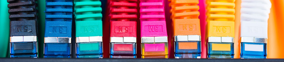 Close-up view of colorful Cat5e Ethernet patch cables lined up side by side, showcasing their vibrant designs, RJ45 connectors, and protective boots for reliable network connections.