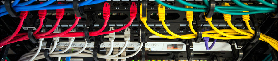 A close-up view of a network setup showcasing multiple Cat6 Ethernet patch cables in various colors (red, yellow, blue, white, and green), neatly connected to a patch panel, ensuring organized and efficient data transmission.