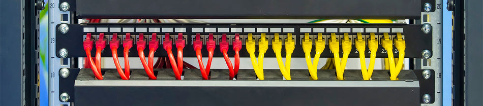A neatly organized patch panel featuring vibrant yellow and red Cat6A patch cables connected to network ports, providing a clear and efficient setup for high-speed data transmission.