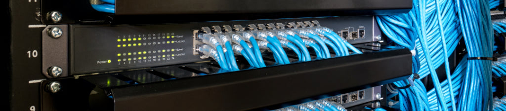 A network rack with switches and blue network cables.