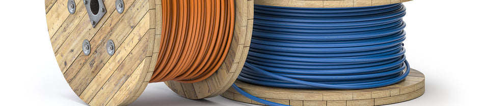 Wooden reels of bulk Ethernet cables, one with orange cable and another with blue cable, neatly wound and ready for networking installations.