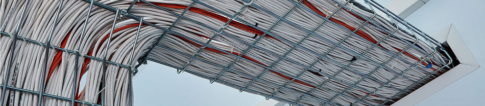 Close-up image of neatly organized network cables routed through a ceiling-mounted wire mesh cable tray, showcasing efficient cable management and high-density wiring.
