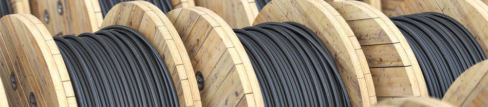 A close-up view of wooden spools neatly wound with black Cat7 bulk Ethernet cable, showcasing the durable and high-quality construction suitable for professional networking installations.
