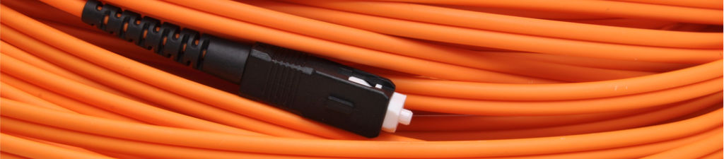 A coiled OM1 single mode patch cable with an orange jacket and black SC connector.