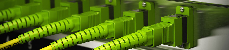 Close-up of vibrant green OM5 fiber optic patch cables securely connected to a high-density patch panel.