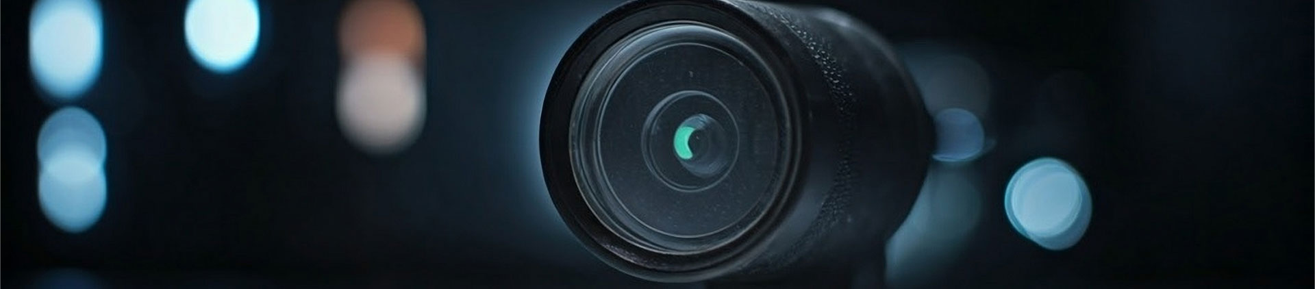 Close-up view of a high-resolution inspection camera lens with a dark blurred background, showcasing its precision optics and professional design.