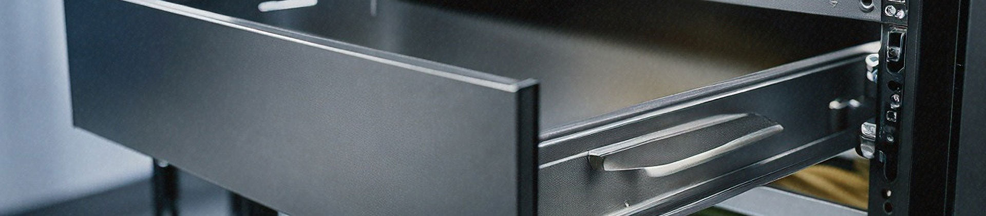 Close-up of a black metal sliding drawer partially extended from a network rack. 