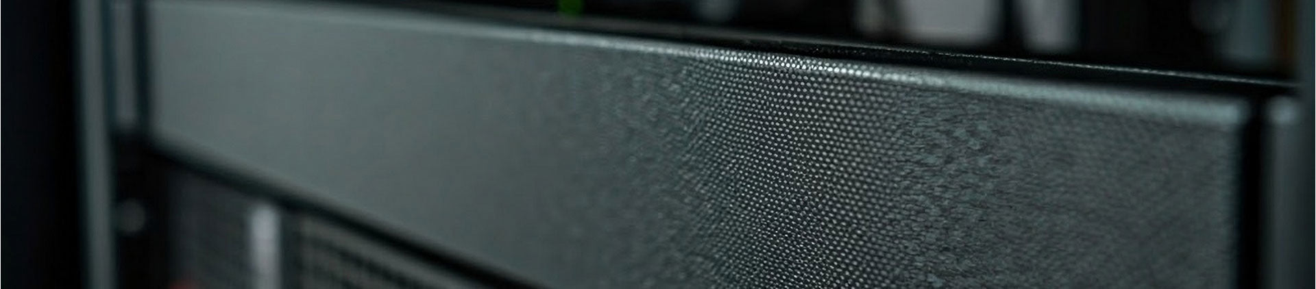 Close-up of a black metal spacer blank panel installed in a network rack.