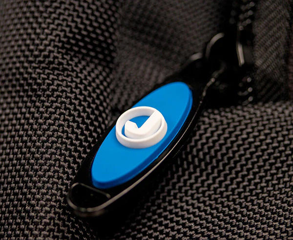 Close-up of a functional blue and white button on a technician's backpack