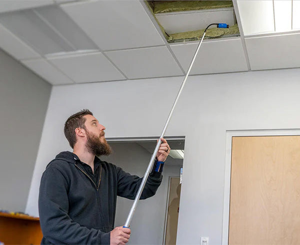 A 5-foot telescoping pole being used to inspect a ceiling