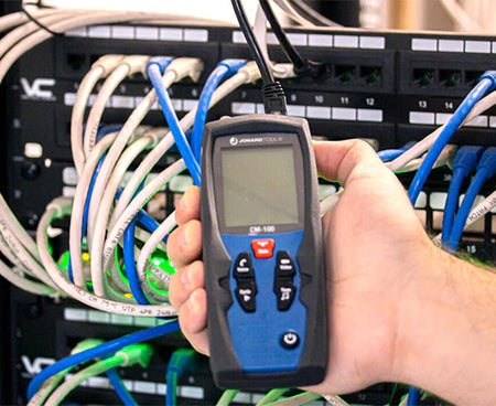Technician programming the Cable Mapper Pro in front of a server rack