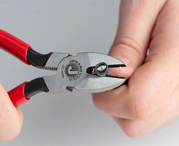 Action shot of someone using telecom diagonal cutters to snip through a coax cable