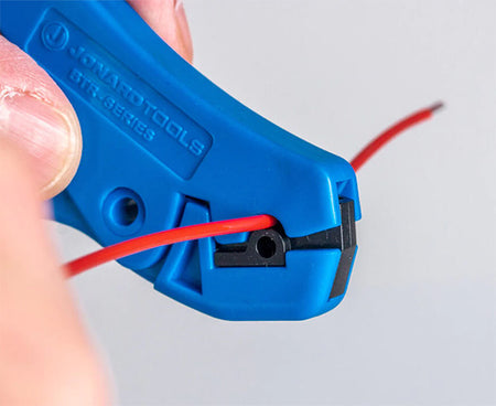 Technician accurately slicing a wire with the kit's specialized blue cutter