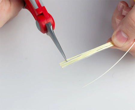 Close-up of the fiber optic preparation kit's scissors trimming fiber