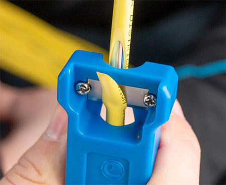 The kit's blue stripping tool  being used in fiber optic preparation