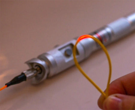 A technician utilizing a fiber optic laser tool from the Ultimate Backpack Fiber Prep Kit