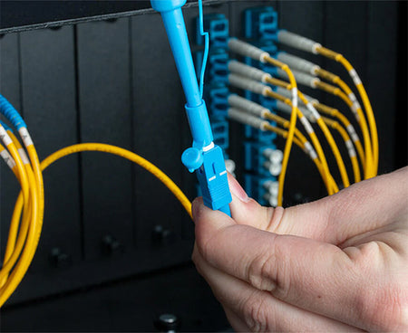 Connection of a blue fiber optic cable using tools from the Ultimate Backpack Fiber Prep Kit