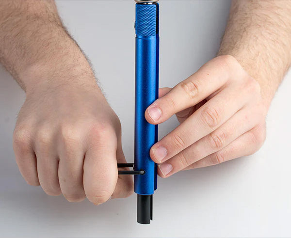 A close view of a hand gripping the blue Trap and Security Combo Tool