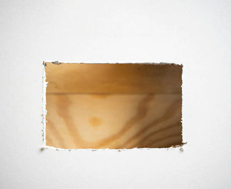 A wooden support used in the demonstration of wall box mounting in a white environment