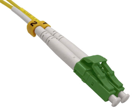 A single LC APC connector with green body, dust caps and locking tab.