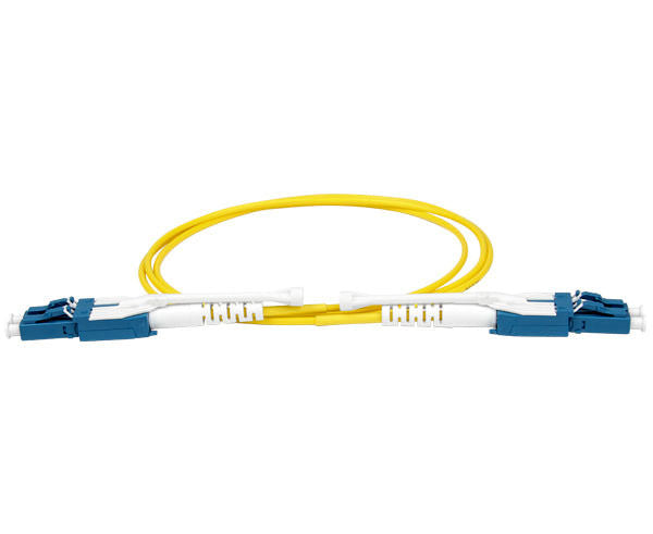 A coiled LC uniboot single mode fiber patch cable with pull/push tab, dust caps, blue body and yellow fiber.